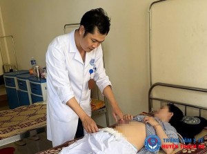 Bác sỹ Trần Thanh Hải, Trưởng khoa CSSKSS và Phụ sản - Trung tâm Y tế Thạch Hà kiểm tra vết mổ cho bệnh nhân.